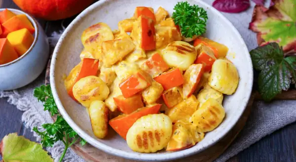 Herzhafte Gnocchi Pfanne mit Kürbis in cremiger Sauce, garniert mit Petersilie. Ein herbstliches Gericht, das wärmt.