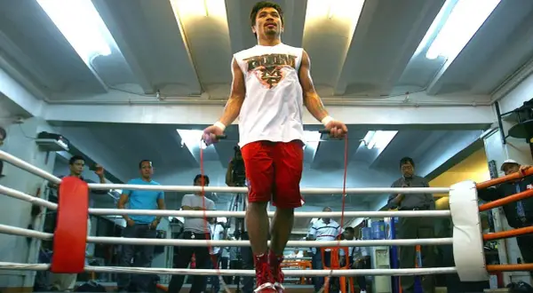 Boxers jump rope to build stamina and footwork. Manny Pacquiao trains in a boxing ring, surrounded by spectators.