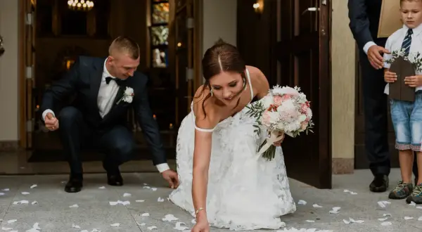 Panna młoda i pan młody zbierają monety po ślubie kościelnym bez mszy.