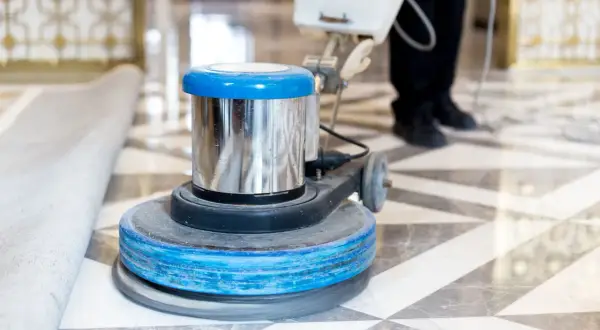 Macchina lucidatrice in azione su un pavimento in marmo. Un professionista sta lavorando per capire come pulire il marmo vecchio, riportandolo al suo antico splendore.