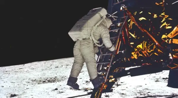 Astronaut schodzi po drabinie modułu księżycowego, rozpoczynając historyczne lądowanie na księżycu.