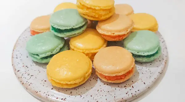 En hög med färgglada macarons i olika smaker, perfekta för ett macarons recept.