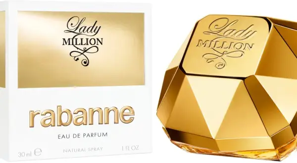 Złoty flakon perfum Lady Million od Rabanne, przypominający diament, obok białego pudełka z napisem "one milon".