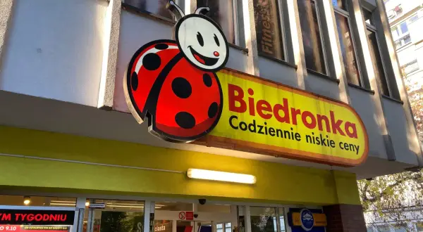 Logo Biedronki i szyld sklepu. Zastanawiasz się, jak odebrać wygraną ze zdrapki Biedronka? Sprawdź w sklepie!