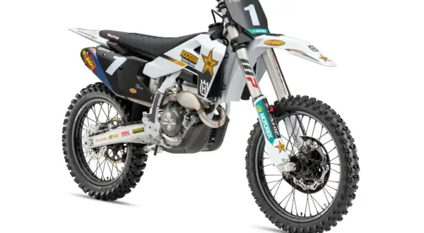 Biały motocykl Husqvarna 250 cross z numerem 1 na tablicy, ozdobiony logotypami Rockstar Energy i Motorex.