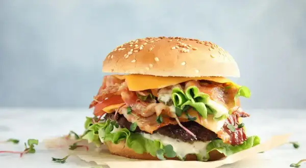 Apetyczny burger z bekonem, serem i warzywami. Zastanawiasz się nad big mac kcal? Ten burger wygląda na sycący!