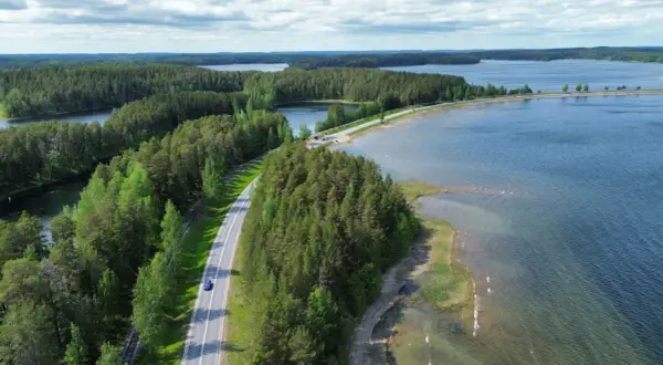 Malownicze jeziora i lasy Finlandii. Droga wije się wśród zieleni, idealna na podróż, by odkryć, co zobaczyć w Finlandii.