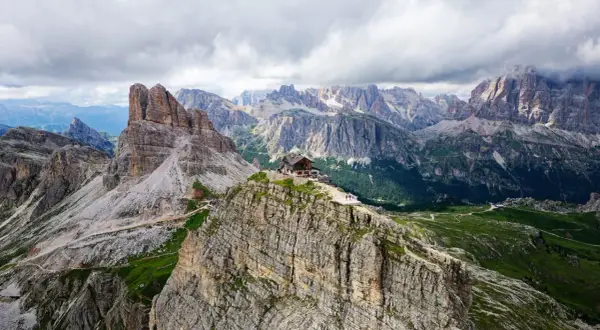 Un refuge de montagne perché sur un pic rocheux, au cœur des Dolomites en Italie. Un paysage spectaculaire de montagnes escarpées et de vallées verdoyantes.
