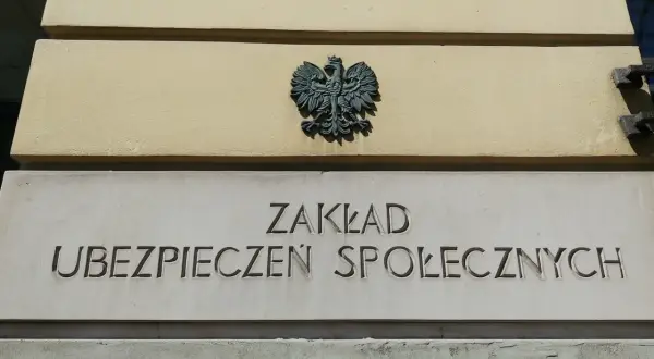 Znak orła i napis "ZAKŁAD UBEZPIECZEŃ SPOŁECZNYCH" na budynku.