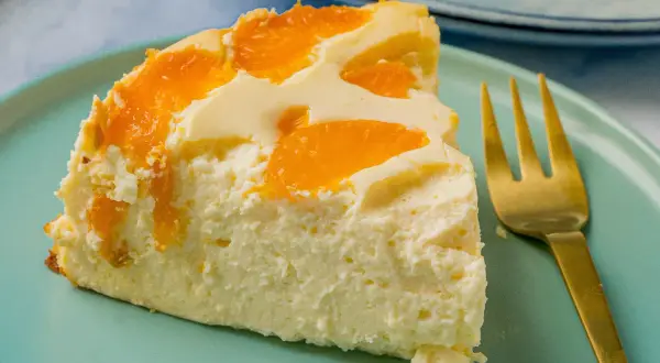 Ein Stück cremiger Quark Joghurt Kuchen mit Mandarinen, bereit zum Genießen. Ein schneller Genuss!