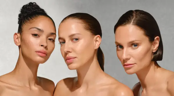 Drei Frauen mit strahlender Haut, die auf die Vorteile von onkologischer Kosmetik hinweisen.