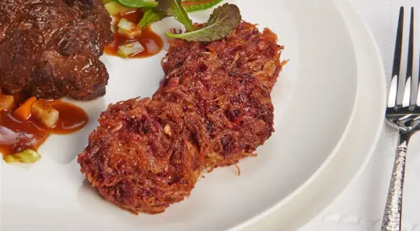 Herzhaftes Rinderfilet mit einer Beilage aus knusprigen rote Bete puffer und frischem Salat.