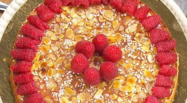 En vacker mandelkaka med citron, toppad med färska hallon och mandelflagor. En härlig sommartårta!