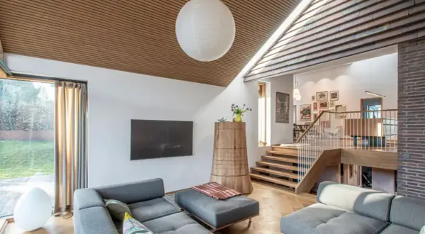 Gemütliches Wohnzimmer in einem Split-Level-Haus mit Holzakzenten, Treppen und gemütlichen Sofas.