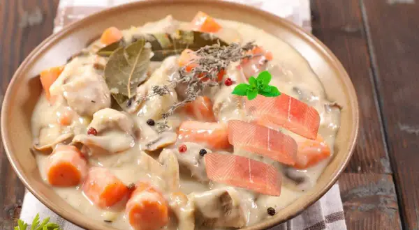 Délicieuse blanquette de poisson crémeuse avec carottes, champignons, herbes et garnie de tranches de saumon frais.