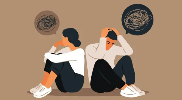 Twee mensen zitten rug aan rug, met hun hoofd in hun handen. Ze voelen zich verloren en alleen, alsof ze je niet thuis voelen bij je familie.