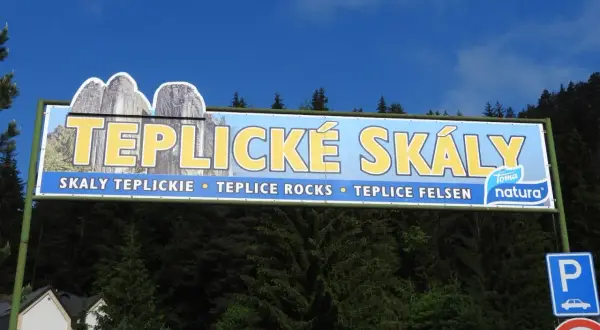 Tablica informacyjna zapraszająca na trasę po skalach w Teplicach. Widoczne skalne formacje i napis "TEPLICKÉ SKÁLY".