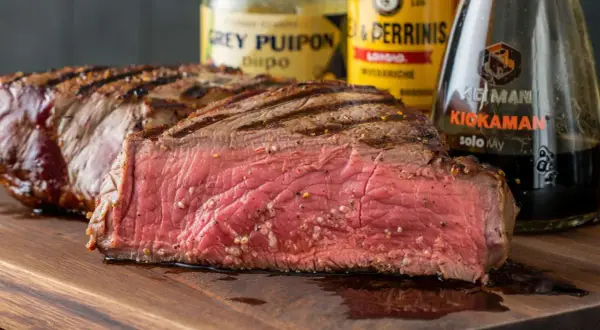 Saftiges Steak, perfekt gegrillt. Die Zutaten für **grillfleisch selber marinieren** liegen bereit: Senf, Worcestershire-Sauce und Sojasauce.