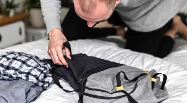 Un homme prépare son sac. Il se demande combien de kilo dans un sac de 30l peut contenir pour son voyage.