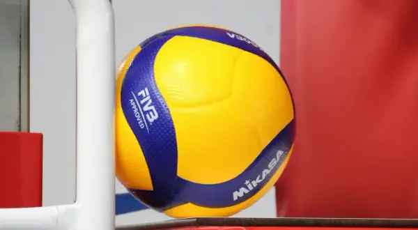 Żółta piłka do siatkówki Mikasa z niebieskimi pasami, z logo FIVB Approved.