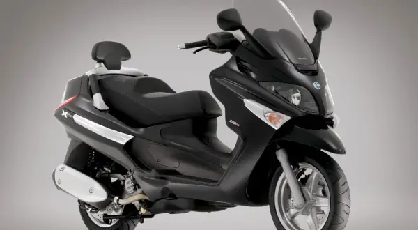 Elegancki, czarny Piaggio X9 250 z wygodnym siedzeniem i dużym przednim wiatrochronem, gotowy na miejskie podróże.