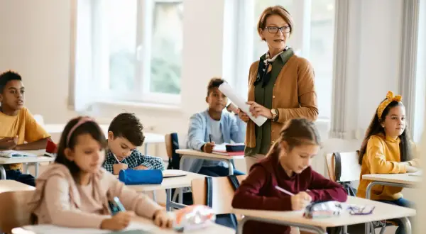 Lehrerin erklärt im Unterricht, während Schüler in Deutschland konzentriert arbeiten. Die Schulnoten sind ein wichtiger Teil des Bildungssystems.