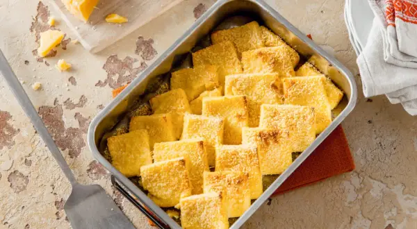 Gebackene Gnocchi alla Romana, goldbraun und mit Parmesan bestreut, bereit zum Servieren. Ein köstliches Rezept für jeden Anlass.