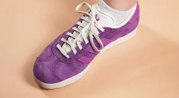 Une chaussure Adidas Gazelle violette, prête à nettoyer pour retrouver son éclat.