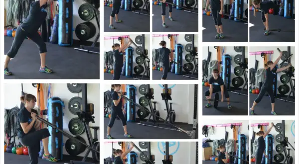 Frau führt eine Landmine Press-Übung mit einer Langhantel aus.