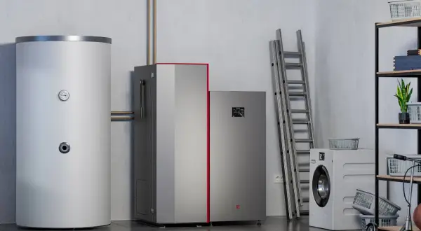 Nowoczesna pompa ciepła obok bojlera i pralki. Wybór między pompą ciepła czy piecem elektrycznym to kluczowa decyzja dla domu.