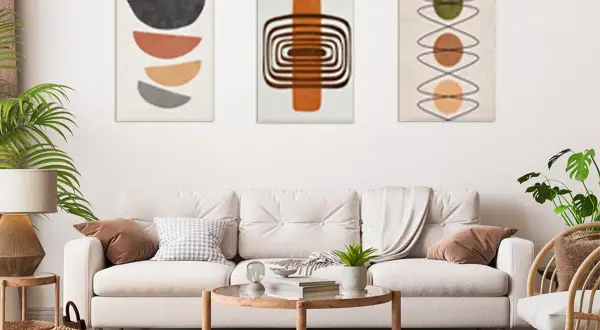 Trzy obrazy w formacie 30x40: geometryczne półkola, spirale i kółka. Nowoczesny salon z sofą i stolikami.