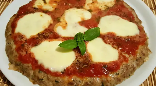 Bistecche alla pizzaiola con mozzarella filante e basilico fresco, un piatto gustoso e invitante.
