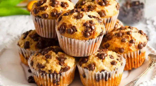 Stos muffinek bananowo czekoladowych, pachnących domem i słodyczą, gotowych do zjedzenia.