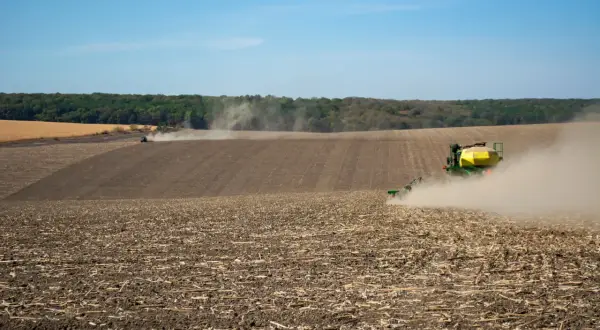 Traktor sieje na polu, wzbijając kurz. Rolnik pracuje, choć dzierżawa bez umowy a dopłaty to niepewna przyszłość.