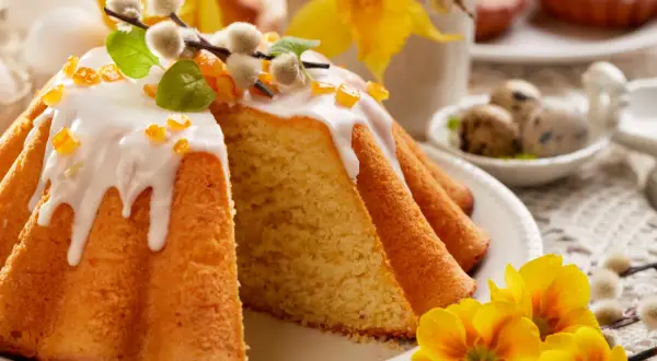 Puszyste ciasto na wielkanoc, polane lukrem i ozdobione baziami, czeka na święta.