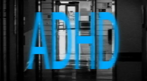 Blå texten "ADHD" över en suddig korridor. Bilden kan symbolisera kampen mot missbruk vid ADHD.