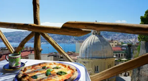 Smakowita pizza i kawa na tarasie z widokiem na Neapol. Ceny we Włoszech mogą być różne, ale takie widoki są bezcenne.