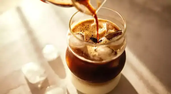 Espresso hälls över is i ett glas, perfekt för ett uppfriskande iskaffe recept.