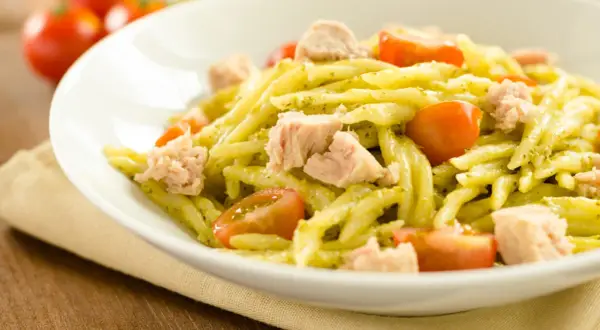 Pasta fredda al pesto con tonno e pomodorini, un piatto estivo fresco e saporito.