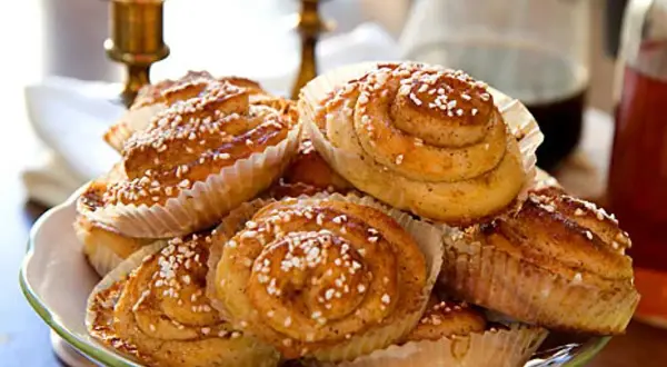 En hög med nybakade kanelbullar, perfekta för ett mysigt fika. Detta kanelbullar recept ger gyllene, sockerströsslade godsaker.