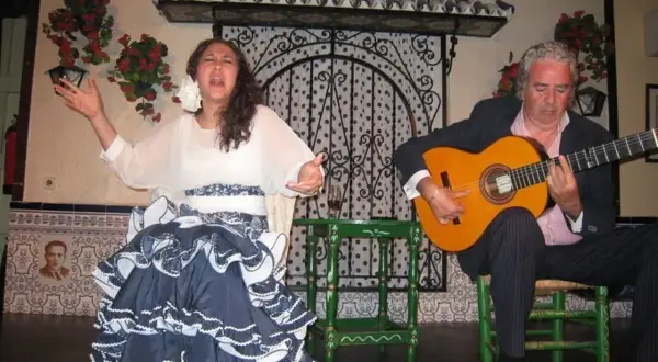Una bailaora flamenca y un guitarrista, ¿de donde viene la palabra ole? La pasión en sus gestos evoca la fuerza de esta exclamación.