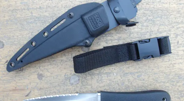 Daga táctica SOG con funda negra y correa de sujeción. Hoja de acero con sierra.