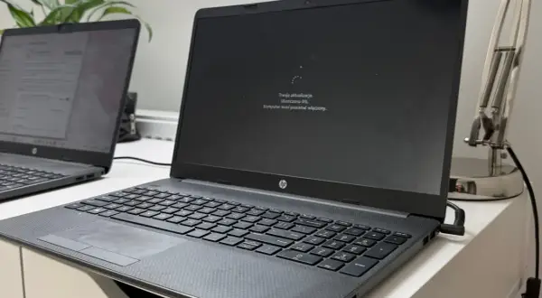 Laptop z ekranem pokazującym komunikat "Trwają aktualizacje. Ukończono 0%. Komputer musi pozostać włączony." - to najnowsza aktualizacja Windows 11.