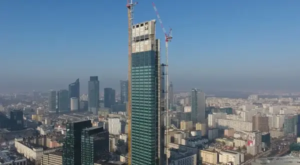 Varso Tower w budowie, z dźwigami na szczycie, góruje nad panoramą Warszawy. Trudno ocenić, ile pięter ma Varso Tower, ale jest to już najwyższy budynek w Polsce.