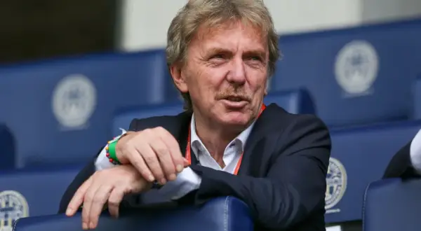 Zbigniew Boniek, żyje i ma się dobrze, siedzi na trybunach w garniturze, z charakterystycznymi wąsami.