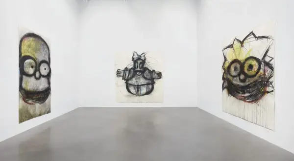 Gallery space with three expressive, cartoon-like portraits by Joyce Pensato.