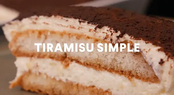 Une part généreuse de tiramisu simple, parfait pour 10 personnes, avec ses couches de biscuits imbibés et de crème onctueuse, saupoudré de cacao.