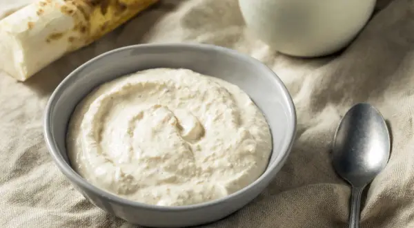 Domowy sos chrzanowy w misce, obok korzeń chrzanu. Po kilku dniach może stracić swój ostry aromat.