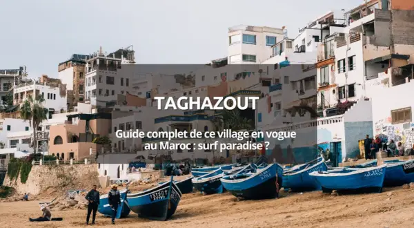 Village de pêcheurs à Taghazout, Maroc. Bateaux bleus sur la plage, maisons blanches perchées. Un paradis pour le surf au Maroc.