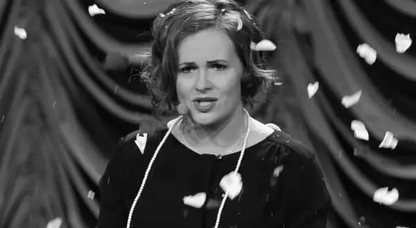 Joanna z kabaretu hrabi, w perłach i z płatkami na głowie, podczas występu.